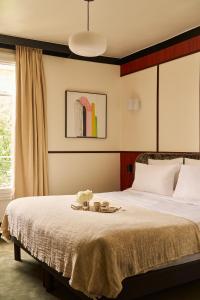 a bedroom with a bed with a tray of flowers on it at Hôtel Marguerite in Paris