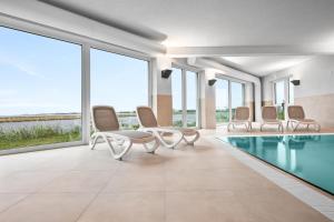 una camera con piscina, sedie e finestre di Hafenspitze a Kappeln
