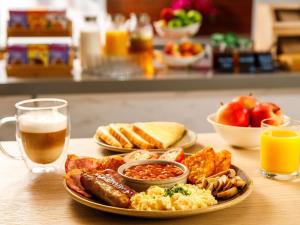 a plate of breakfast food and a glass of beer at ibis budget Leicester in Leicester +50 photos
