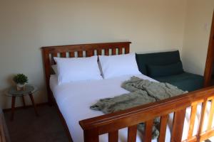 een bed met een deken en een stoel in een kamer bij Black Rock Cottage in Camperdown +19 foto's