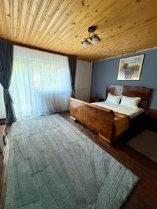 a bedroom with a bed and a wooden ceiling at Luna House Busteni in Buşteni