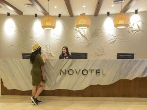 two women standing at a novoited counter in a lobby at Novotel Cairo El Borg in Cairo