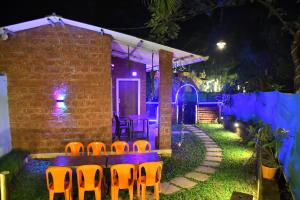 a table and chairs in front of a house at night at Shivai holiday home in Alibaug