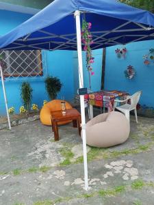 a blue umbrella sitting next to a table and a chair at La Chambre bleue in Libreville