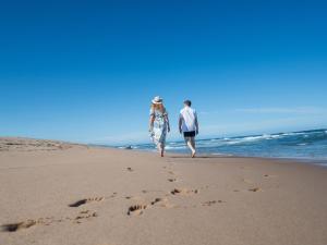 Ein Paar spaziert am Strand entlang, Fußspuren im Sand in der Unterkunft ANEW Hotel Ocean Reef Zinkwazi in Zinkwazi Beach