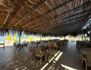 a restaurant with tables and chairs and umbrellas at Özen Otel in Ayvalık