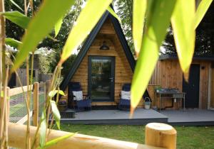 a log cabin with a porch and a desk at Sycamore Lodge with Hot Tub- Quirky & Romantic in Halstead