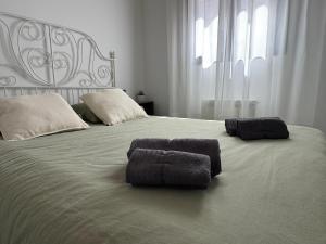 a large white bed with two towels on it at Las Arcas, cómodo apartamento cerca del centro in Valladolid