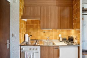 a small kitchen with a sink and a stove at Central studio in Villars sur Ollon, Emeraude, for 3 only 100m to Bretaye ski train in Villars-sur-Ollon