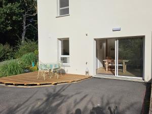 Appartement entouré de verdure في Saint-Martin-de-Seignanx: فناء مع طاولة وكراسي على السطح