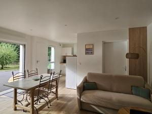 Appartement entouré de verdure في Saint-Martin-de-Seignanx: غرفة معيشة بها أريكة وطاولة