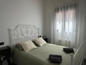 ein weißes Schlafzimmer mit einem großen Bett und einem großen Fenster in der Unterkunft Las Arcas, cómodo apartamento cerca del centro in Valladolid + 28 Fotos