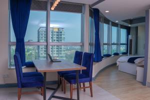 イスラマバードにあるWalk-Inn Hospitality Group Centaurusのテーブルと青い椅子付きの部屋、ベッドルーム1室が備わります。