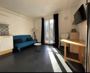 a living room with a blue couch and a table at Studio cabine 4 personnes in Les Angles