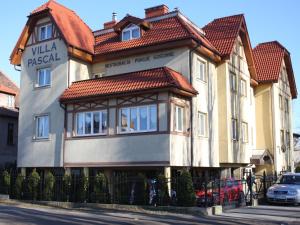 una casa con techo rojo en una calle en Villa Pascal, en Gdansk