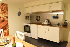 cocina con armarios blancos, fregadero y mesa en Apartment in the middle of Hudiksvall #2, en Hudiksvall