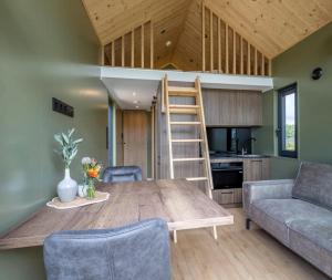 una sala de estar con una mesa de madera y un loft en Brouwershof, en Ooien