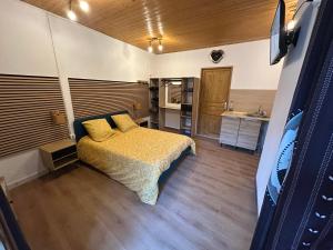 a small bedroom with a bed and a kitchen at Imprevu in La Voulte-sur-Rhône