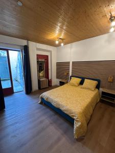 a bedroom with a large bed with a wooden ceiling at Imprevu in La Voulte-sur-Rhône