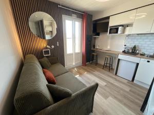a living room with a couch and a kitchen at Studio 138 in Annecy