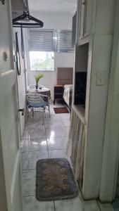 a hallway of a room with a table and a dining room at Apartamento kitnet frente ao mar in São Vicente