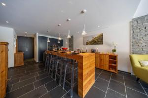 a kitchen with a bar with stools at Le Bouquetin l Ski-out l Sauna in Siviez