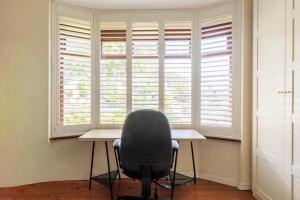 einem Stuhl, der an einem Schreibtisch vor einem Fenster sitzt in der Unterkunft GuestReady - Stylish Dublin Getaway in Dublin