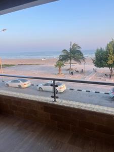 a view of a beach with three cars parked on the street at The Apparte Salalah in Ţāqah