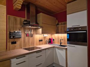 a kitchen with white cabinets and a stove top oven at Chaletwohnung Innerkrems in Innerkrems +18 photos