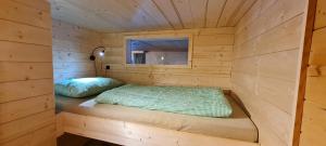 a small room with a bed in a wooden cabin at Chaletwohnung Innerkrems in Innerkrems