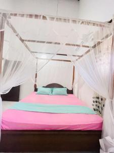 a bedroom with a bed with a mosquito net at Veron Marina Villa in Unawatuna