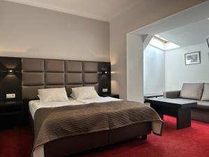 una camera da letto con un letto grande e un divano di REST HOTEL VARIA Działdowo a Działdowo Altre 55 foto