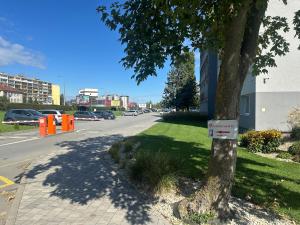 a tree on the side of a street with a sign on it at 111Apartments in Košice