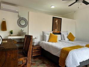 Un dormitorio con dos camas y un escritorio y un espejo. en Mad Safari Bush Camp, en Phalaborwa 27 fotos más