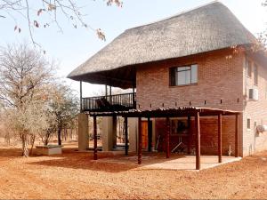 un gran edificio de ladrillo con techo de paja en Mad Safari Bush Camp, en Phalaborwa