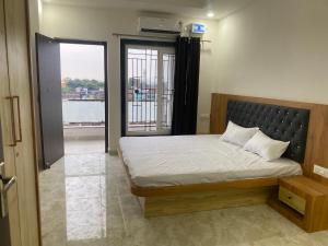 a bedroom with a bed and a door to a balcony at People Leaf Homestay in Gaya