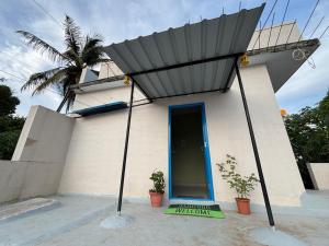 una casa con una porta blu davanti di The Pepper Room a Chikmagalūr