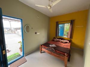 una camera da letto con un letto in una stanza con una finestra di The Pepper Room a Chikmagalūr
