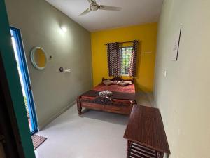 una camera da letto con un letto e una finestra di The Pepper Room a Chikmagalūr Altre 11 foto