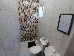 a bathroom with a toilet and a sink and a mirror at Pousada Imperatriz in Aparecida +40 photos