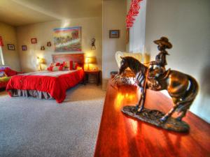 a bedroom with a horse statue on a table in front of a bed at Stagecoach Trails Guest Ranch in Yucca +67 photos