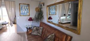 Una sala de estar con un sofá y un espejo. en Sunset Relax Porch, en Lagos