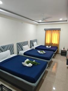due letti in una stanza con lenzuola blu di Mehmaan Guest House a Hyderabad