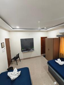 una camera con due letti e una TV a schermo piatto di Mehmaan Guest House a Hyderabad
