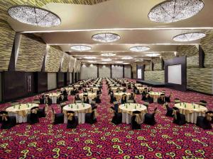 a large banquet hall with tables and chairs at Novotel Lampung in Bandar Lampung