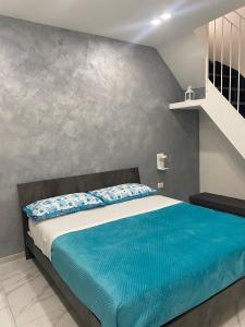 a bedroom with a large bed with blue sheets at Il Vicoletto room in Mercato San Severino