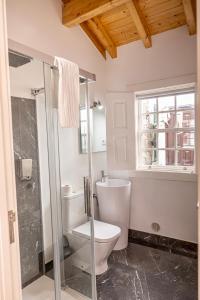 a bathroom with a toilet and a glass shower at Alojamento 5 de Outubro in Amarante +7 photos