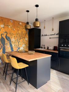 eine Küche mit Tisch und Stühlen und einer Wand in der Unterkunft Ecrin de Charme in Granville + 76 Fotos