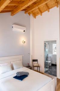 a bedroom with a white bed with a blue towel on it at Alojamento 5 de Outubro in Amarante