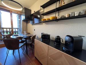 a kitchen with a table and a dining room at Studio fraîchement rénové proche pistes in Les Coches